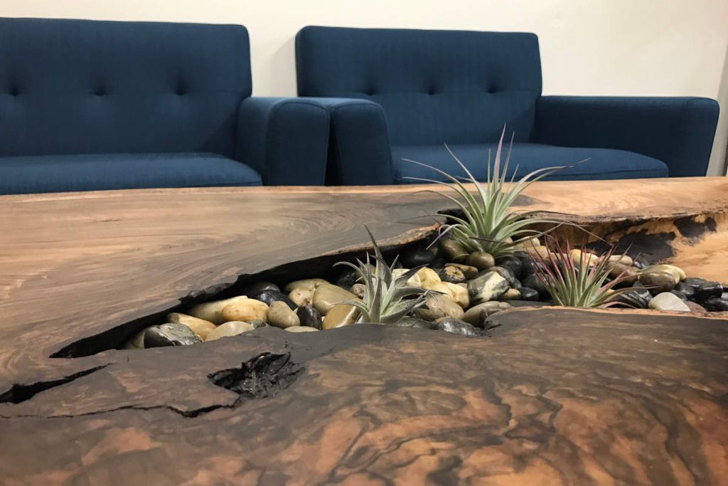Large wooden table with stone and plant decorations