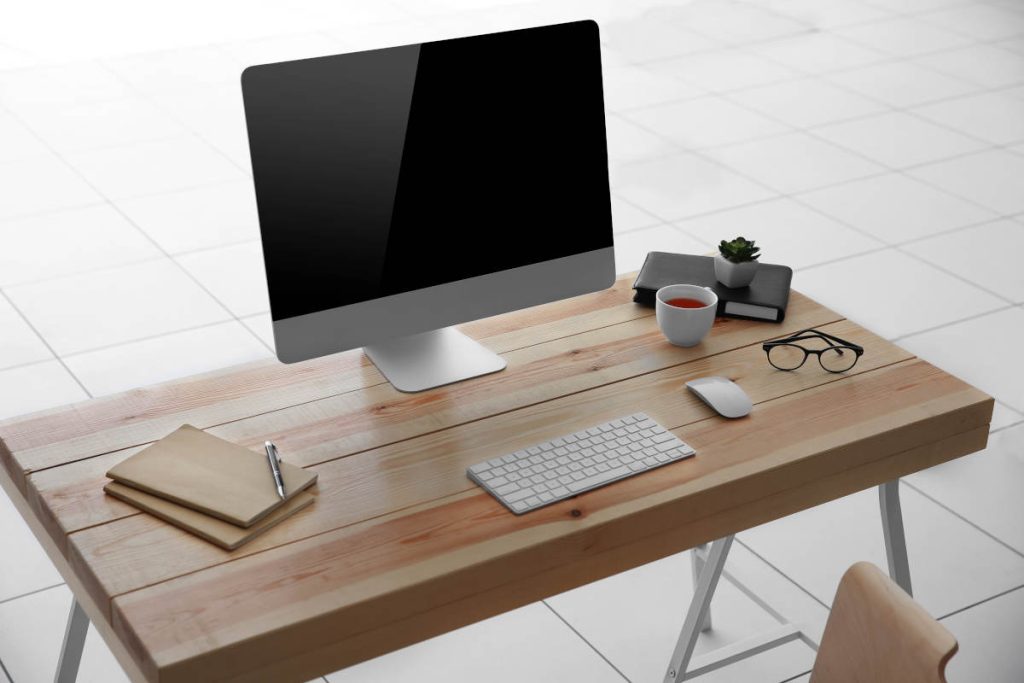 Woden desk working at a computer